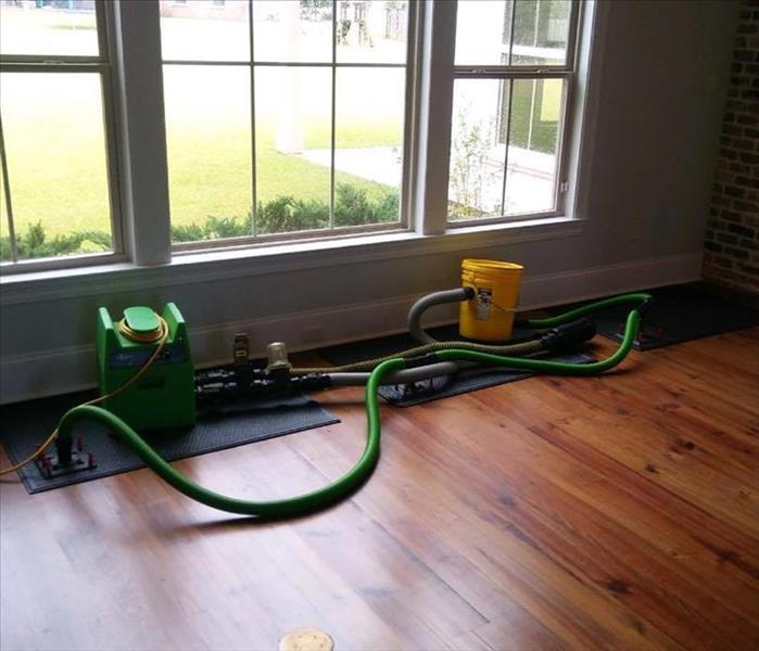 mats and hoses on top of wood flooring with window facing green backyard 