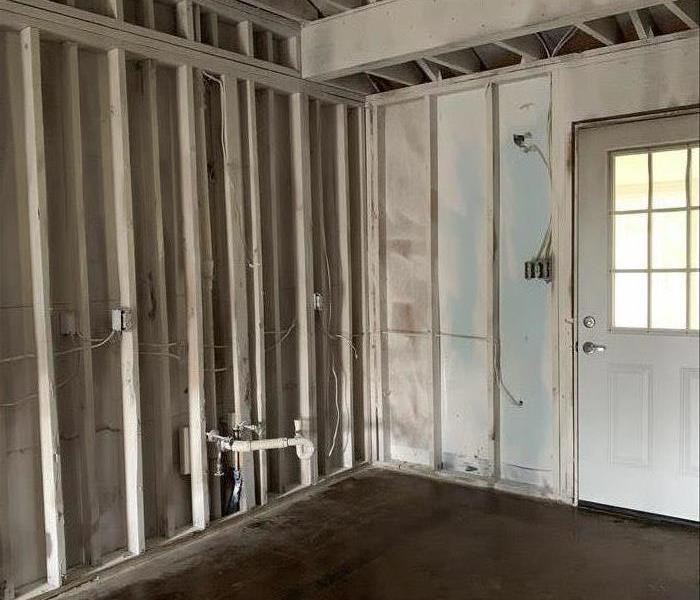 empty kitchen with white studs and concrete floor 