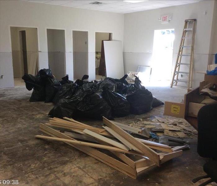 garbage bags and debris pile in room with doors and carpet removed 