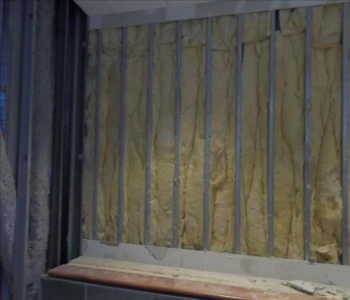 commercial wall with no sheetrock with exposed metal and yellow insulation