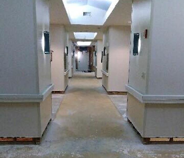 empty hallway of senior living facility with baseboards and flooring removed