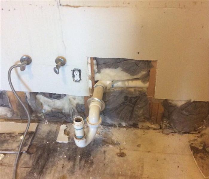 exposed plumbing with sheetrock cut out 