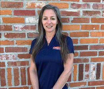 Female SERVPRO office manager standing in front of front door