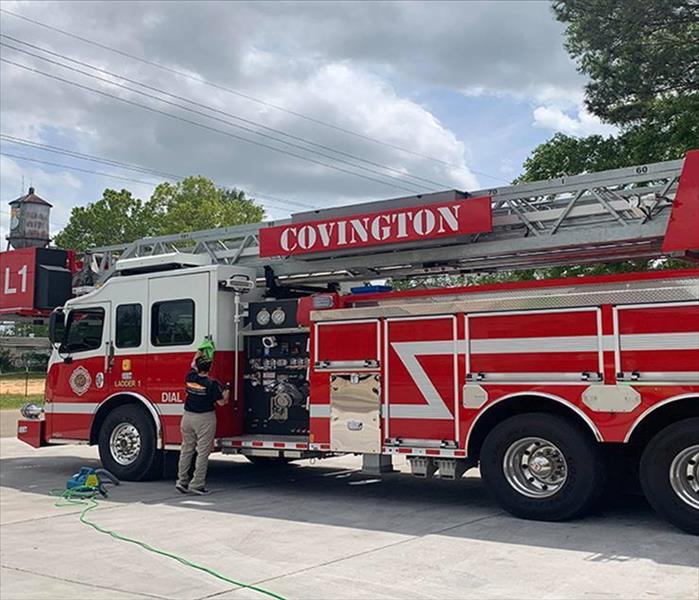 SERVPRO technician cleaning outside of fire truck 