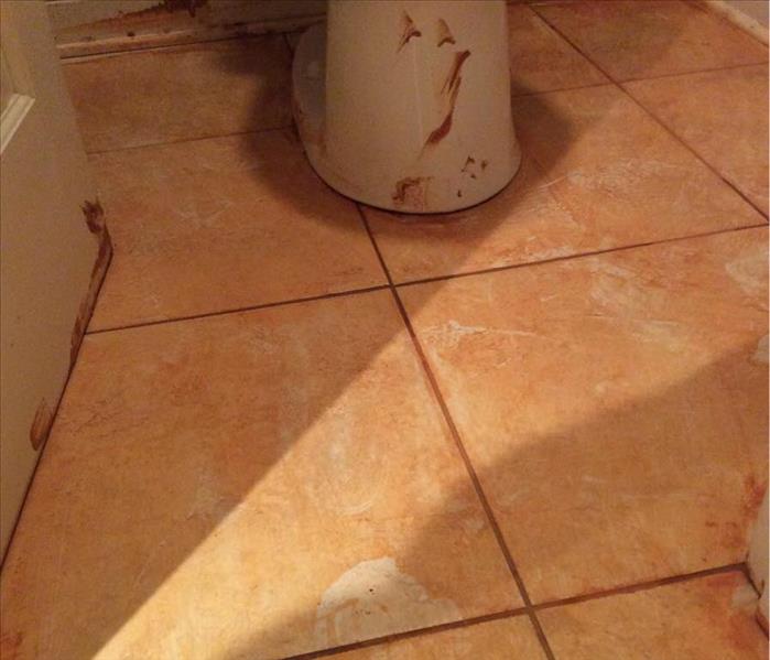 red clay on tile floor and bottom of toilet