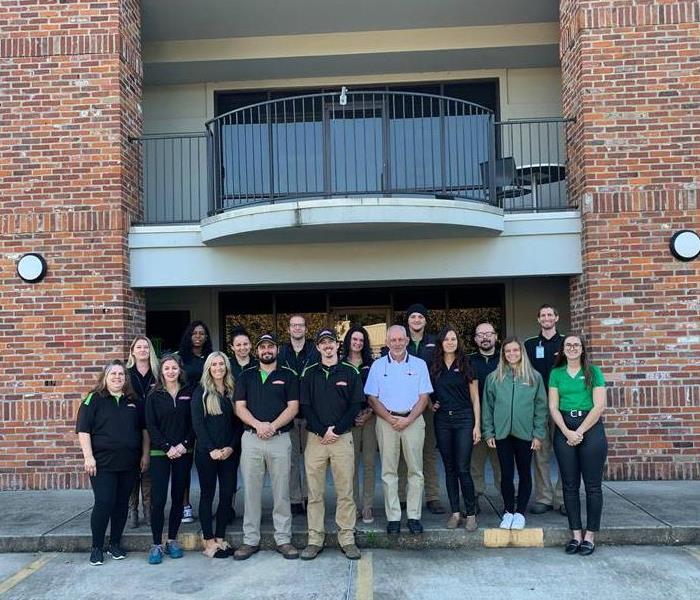 SERVPRO of Greater Covington and Mandeville employees standing in front of brick building 