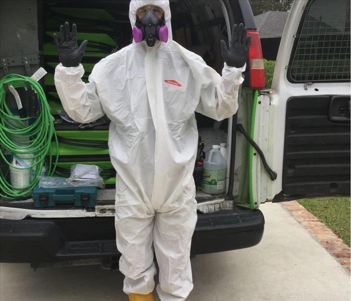 man in white hazmat suit, gloves, and respirator