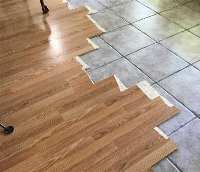 Laminate flooring being removed with tile underneath