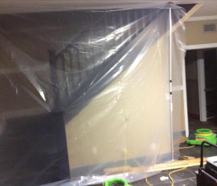 plastic sheet covering staircase with green fans in living room