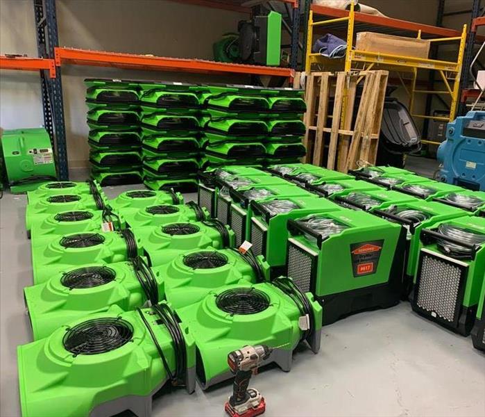 green fans, dehumidifiers, and drying equipment in warehouse 