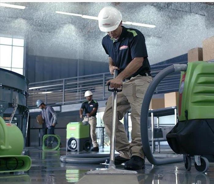 water restoration technician extracting water in commercial building