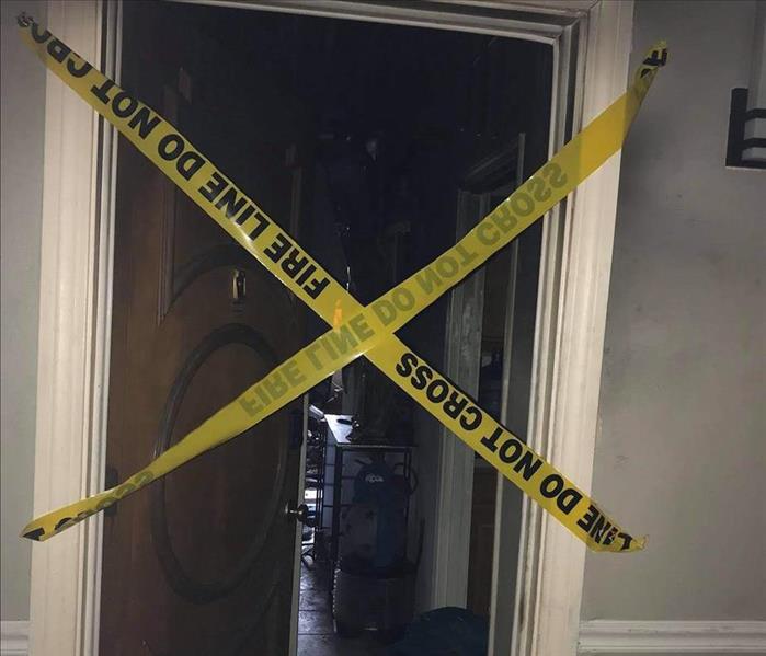 caution tape across open apartment door where contents show fire damage